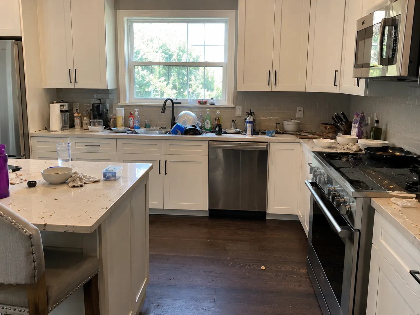 Kitchen counters covered with items and dishes before a cleaning visit